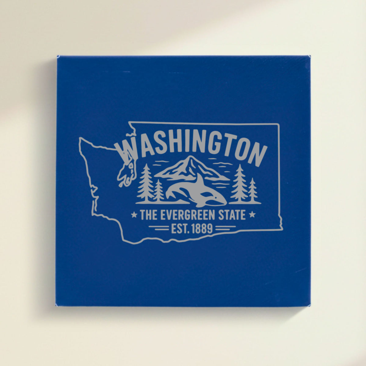 Close up of the Washington design engraved on Blue leatherette: an orca, Mount Rainier and evergreens, "The Evergreen State", EST. 1889
