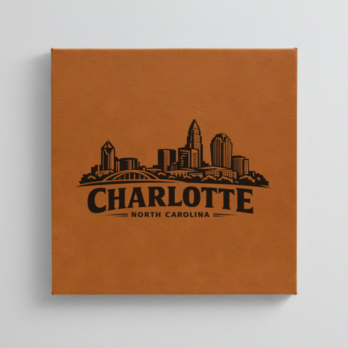 Close up of the Charlotte, North Carolina skyline engraved on Brown leatherette