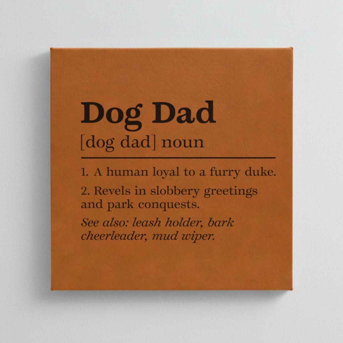 Close-up of the brown leatherette wall sign engraved with the Dog Dad dictionary definition