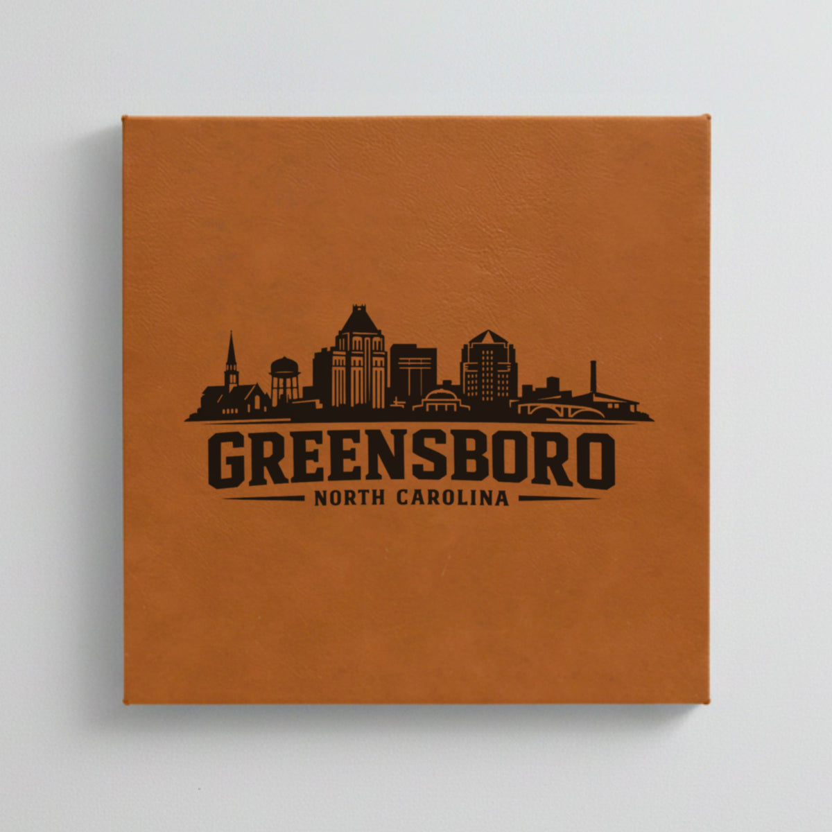 Close up of the Greensboro, North Carolina skyline engraved on Brown leatherette