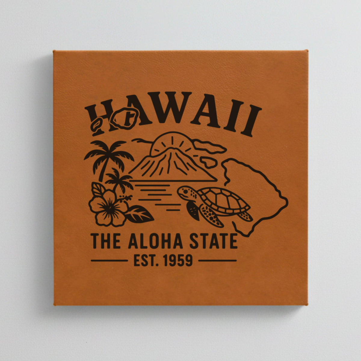 Close up of the Hawaii design engraved on Brown leatherette: a volcano, palm trees, a hibiscus and a sea turtle, "The Aloha State", EST. 1959