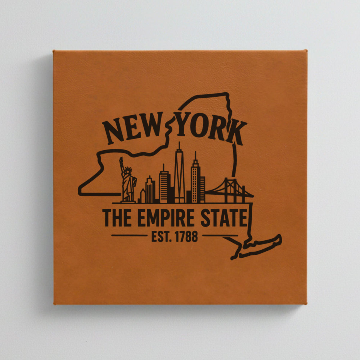 Close up of the New York design engraved on Brown leatherette: the Statue of Liberty and the Manhattan skyline, "The Empire State", EST. 1788