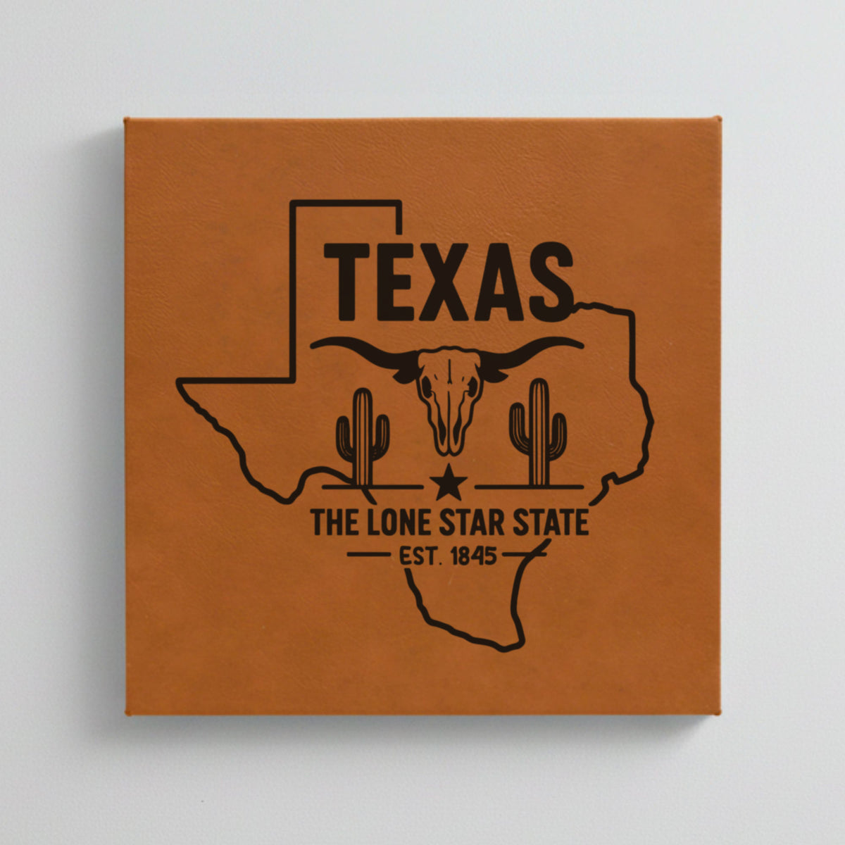 Close up of the Texas design engraved on Brown leatherette: a longhorn skull, cactus and a lone star, "The Lone Star State", EST. 1845