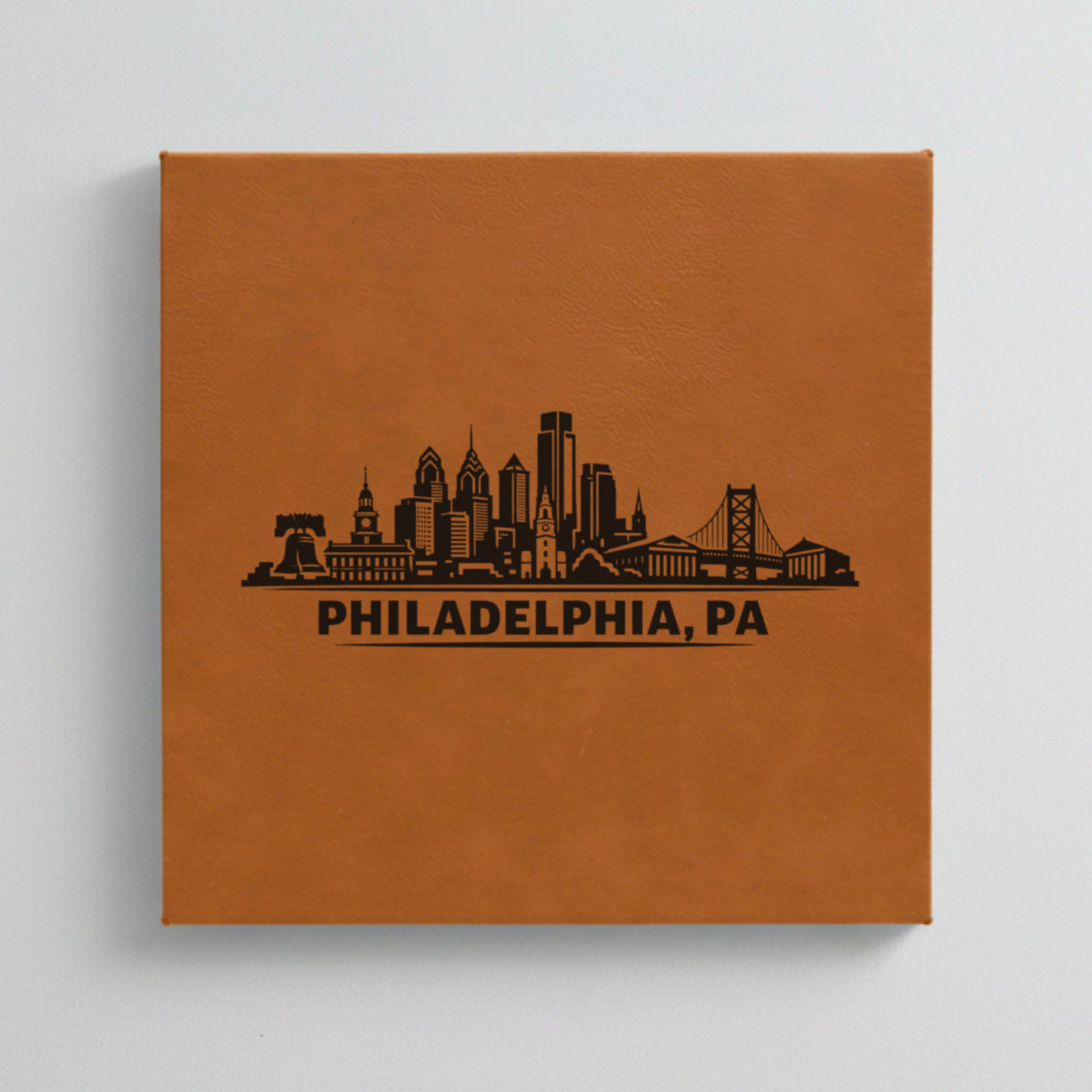 Close up of the Philadelphia, Pennsylvania skyline engraved on Brown leatherette