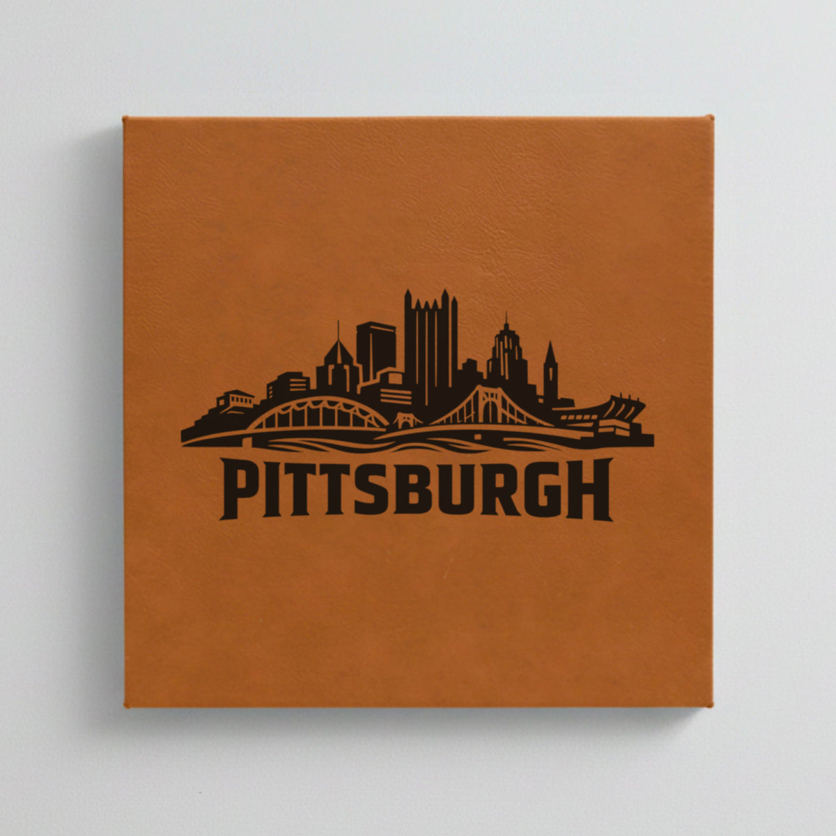 Close up of the Pittsburgh, Pennsylvania skyline engraved on Brown leatherette