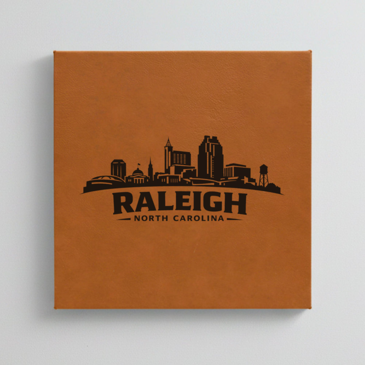 Close up of the Raleigh, North Carolina skyline engraved on Brown leatherette