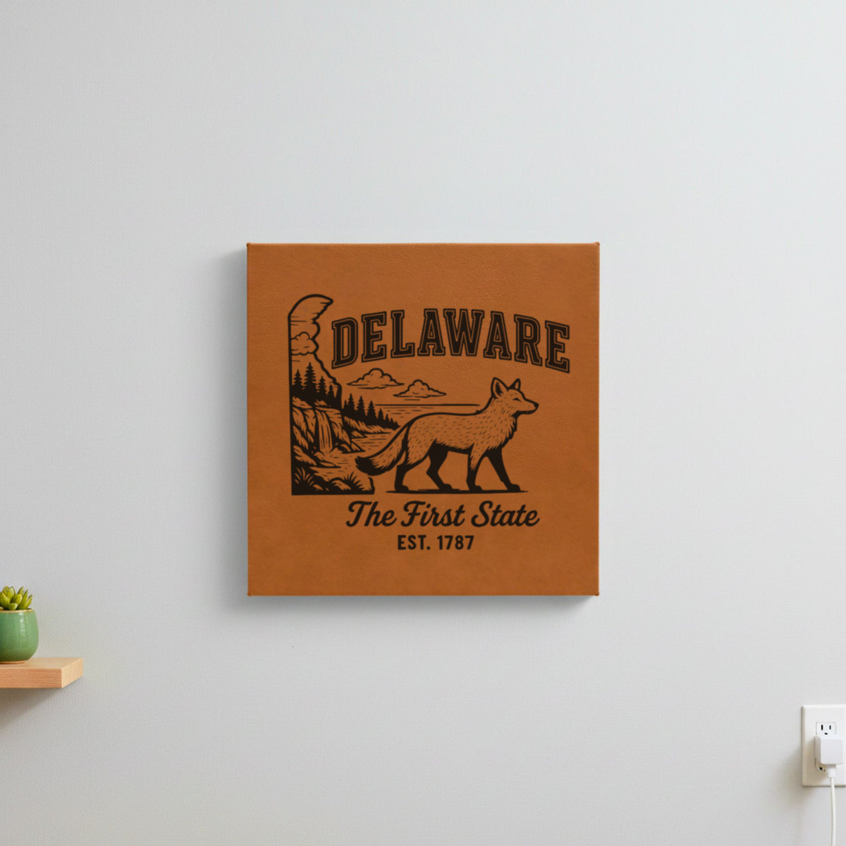 Brown leatherette wall sign engraved with a Delaware design of a gray fox, a waterfall and pine forest, hanging on a wall