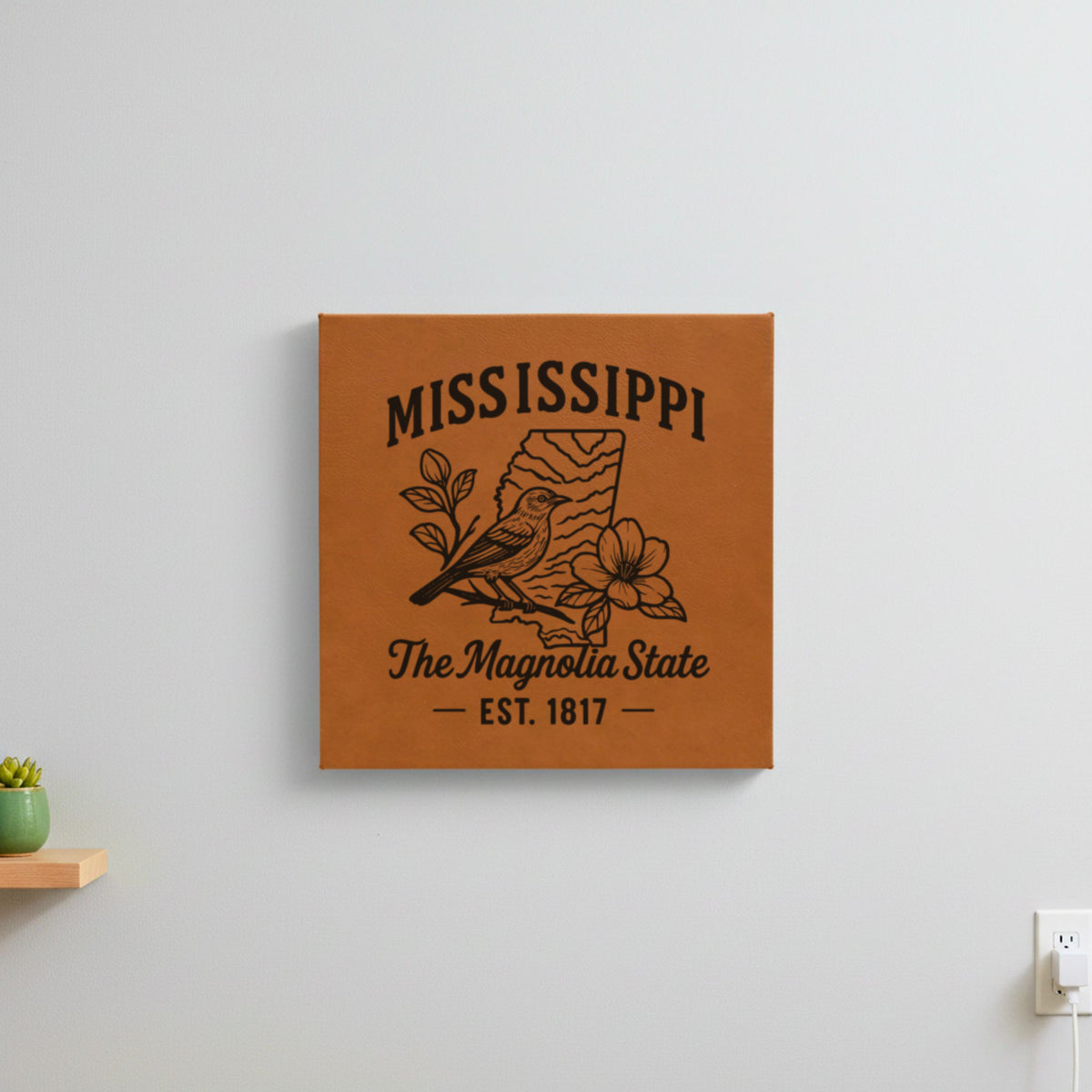 Brown leatherette wall sign engraved with a Mississippi design of a mockingbird and magnolia blossoms, hanging on a wall