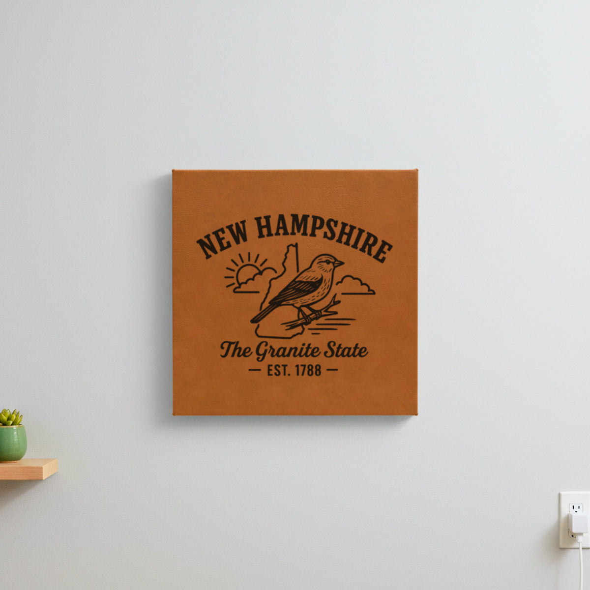 Brown leatherette wall sign engraved with a New Hampshire design of a purple finch, hanging on a wall