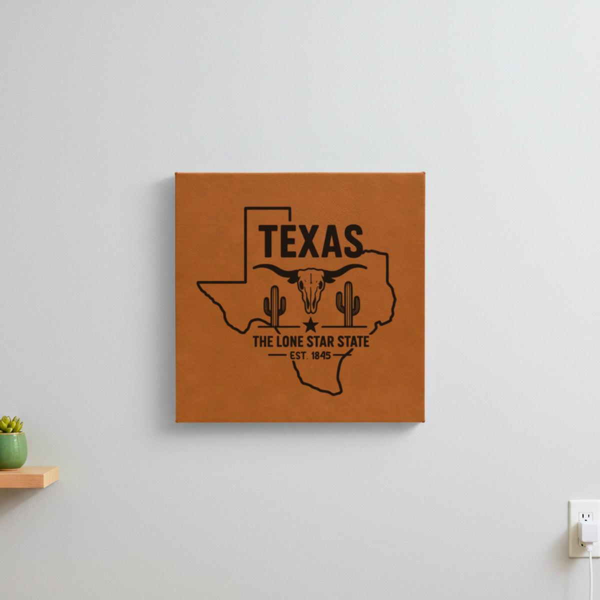 Brown leatherette wall sign engraved with a Texas design of a longhorn skull, cactus and a lone star, hanging on a wall