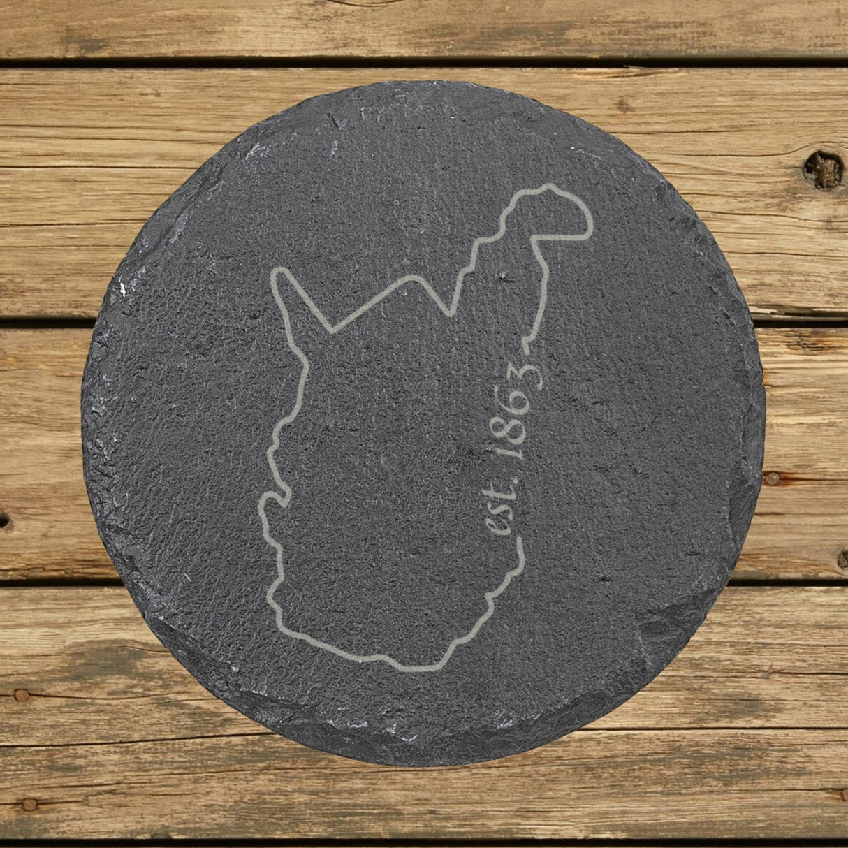 West Virginia round slate coaster engraved with the state outline and est. 1863