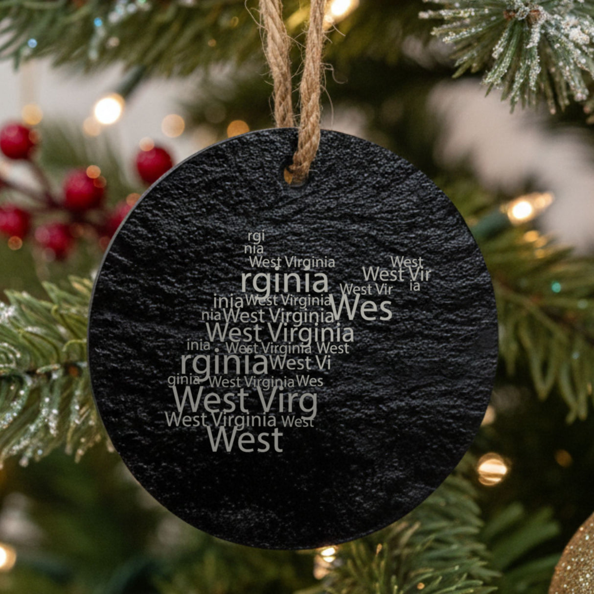 West Virginia round slate Christmas ornament engraved with a word cloud of repeating West Virginia text