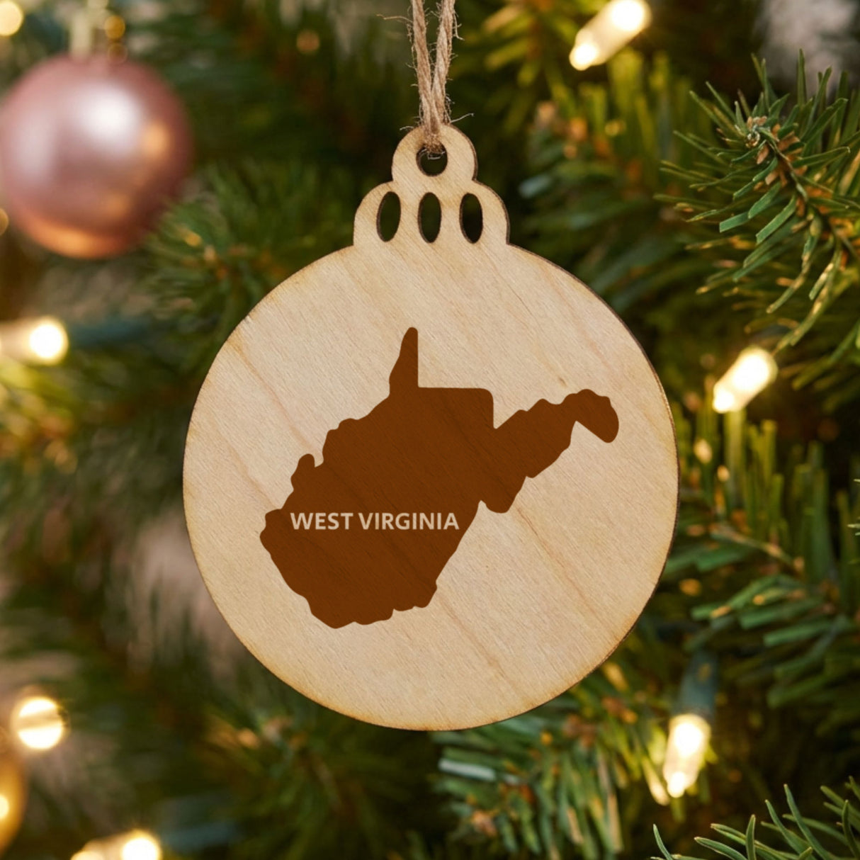West Virginia round wood Christmas ornament engraved with the state shape and WEST VIRGINIA in bold lettering