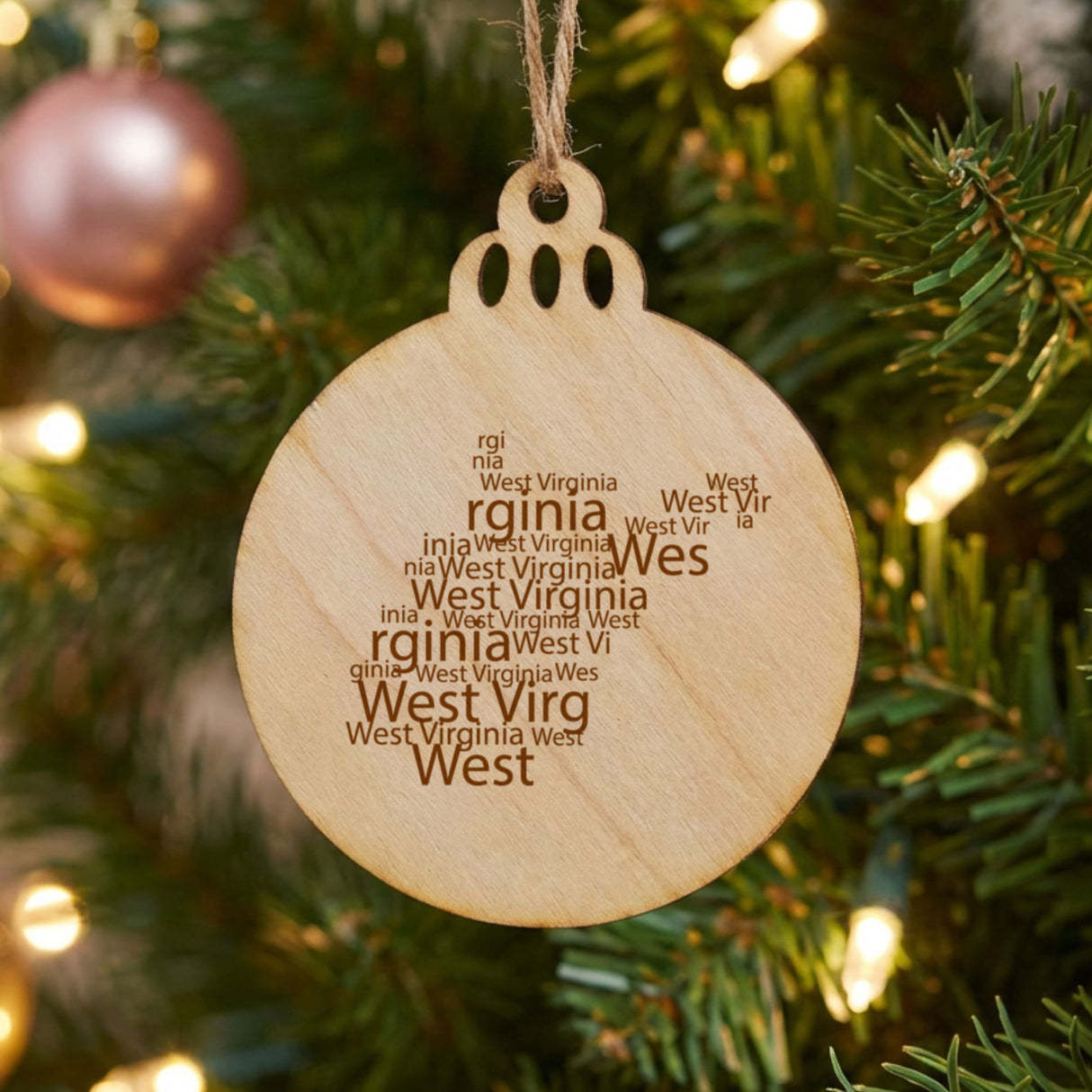 West Virginia round wood Christmas ornament engraved with a word cloud of repeating West Virginia text