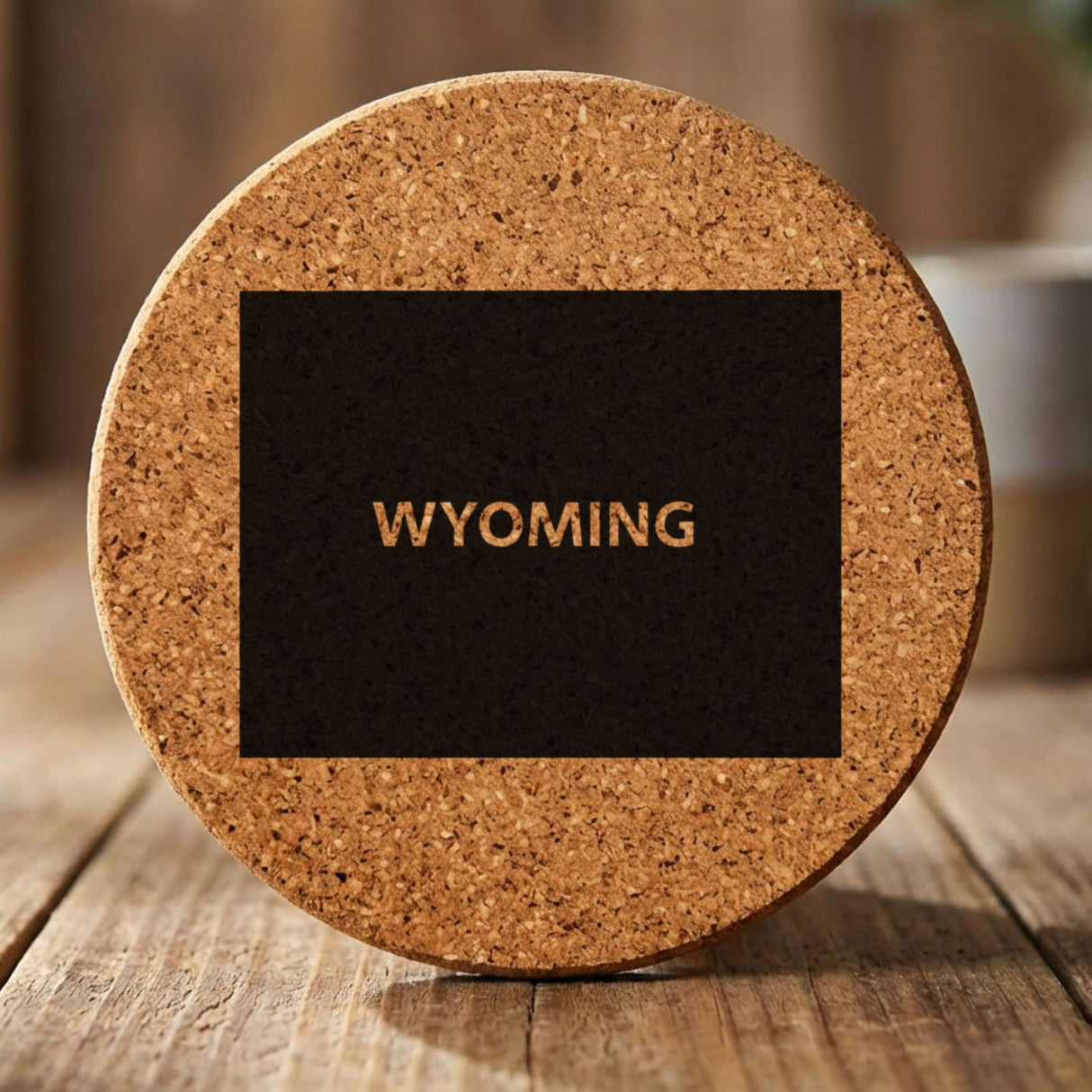 Wyoming round cork coaster engraved with the state shape and WYOMING in bold lettering