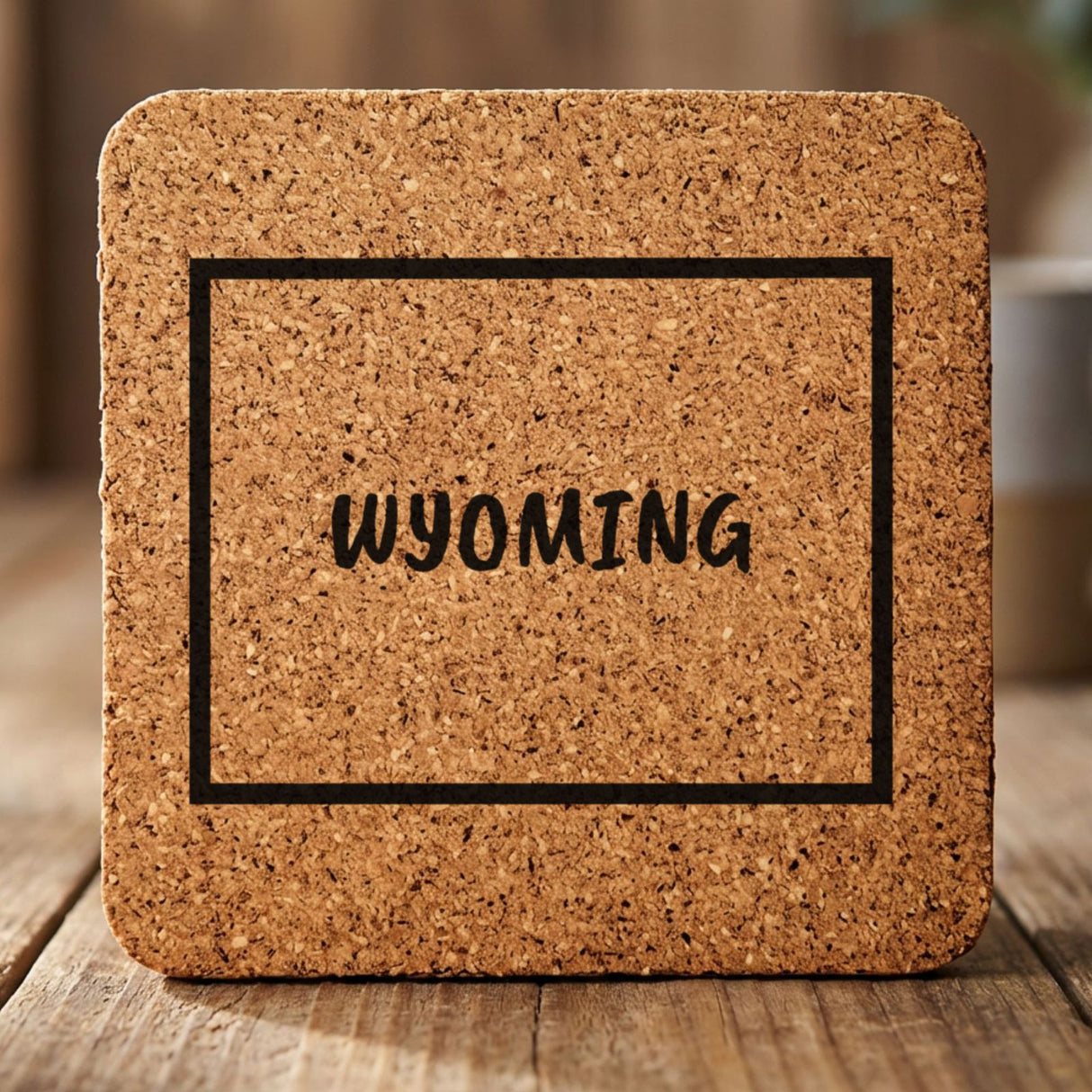 Wyoming square cork coaster engraved with the state outline and WYOMING in hand-drawn brush lettering