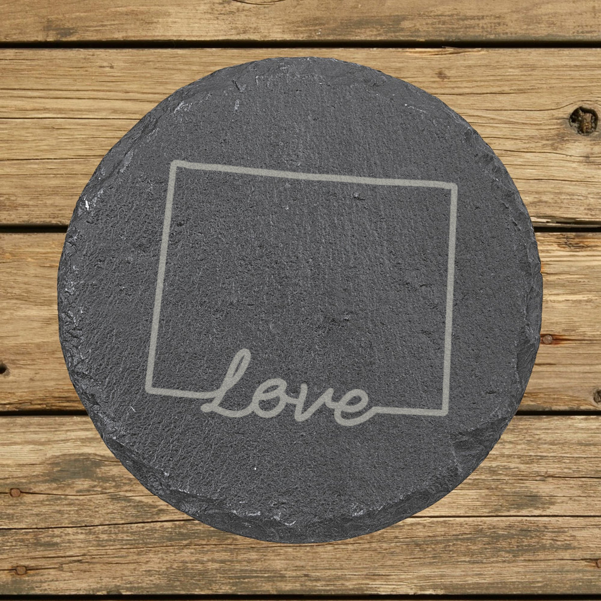Wyoming round slate coaster engraved with a hand-drawn state outline and love in cursive