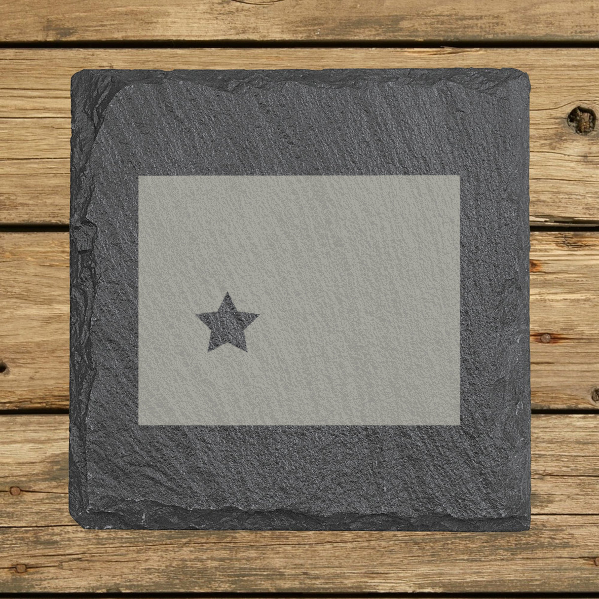 Wyoming square slate coaster engraved with the state shape and a star