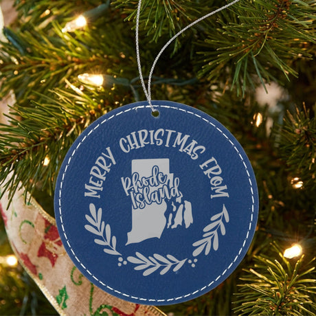 Blue leatherette round Christmas ornament engraved Merry Christmas From Rhode Island, with the state shape in a laurel wreath