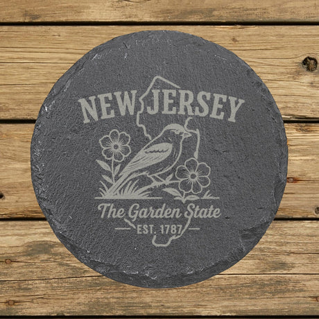 New Jersey round slate coaster engraved with the state outline, an American goldfinch and violets, The Garden State