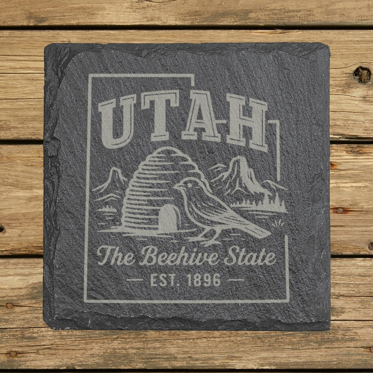 Utah square slate coaster engraved with the state outline, a beehive, a California gull and red rock arches, The Beehive State
