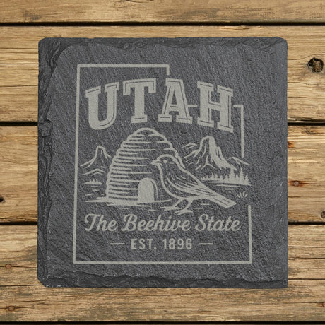 Utah square slate coaster engraved with the state outline, a beehive, a California gull and red rock arches, The Beehive State