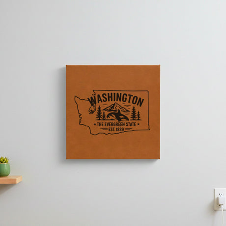 Brown leatherette wall sign engraved with a Washington design of an orca, Mount Rainier and evergreens, The Evergreen State, hanging on a wall