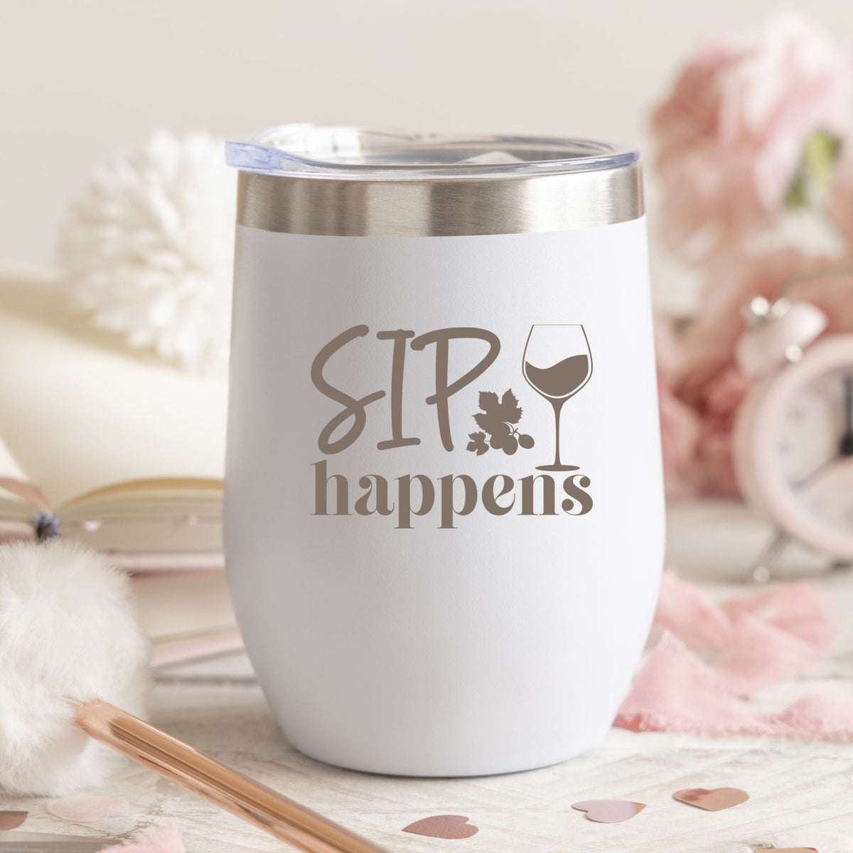 white white tumbler sitting on a table with the saying sip happens and a wine glass on it 