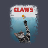 A graphic print featuring a tabby cat reaching upward with one paw toward a small yellow fish floating on the water surface, with the word 'CLAWS' in large red letters above. The artwork is centered on a dark gray background.