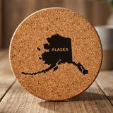 Alaska round cork coaster engraved with the state shape and ALASKA in bold lettering