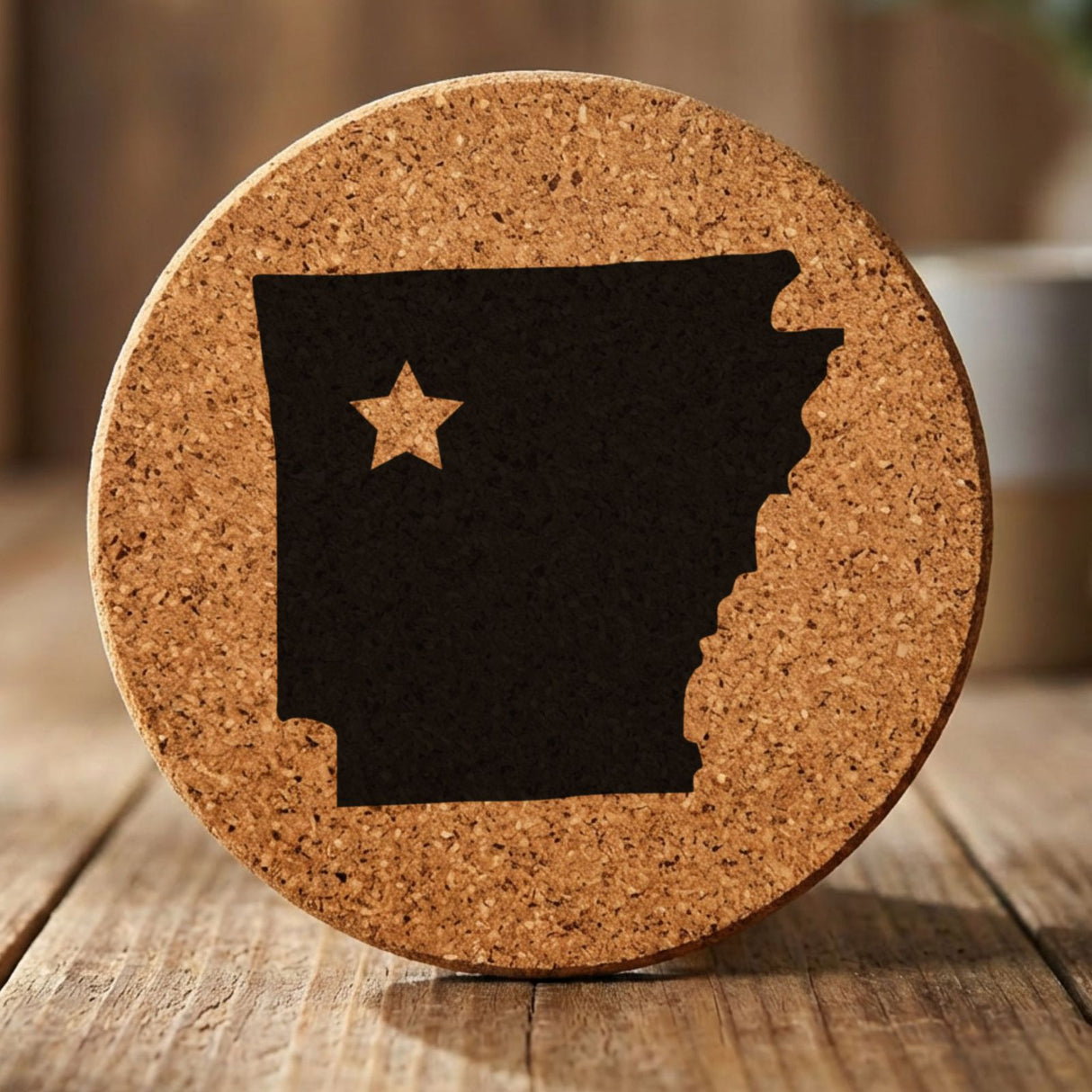 Arkansas round cork coaster engraved with the state shape and a star