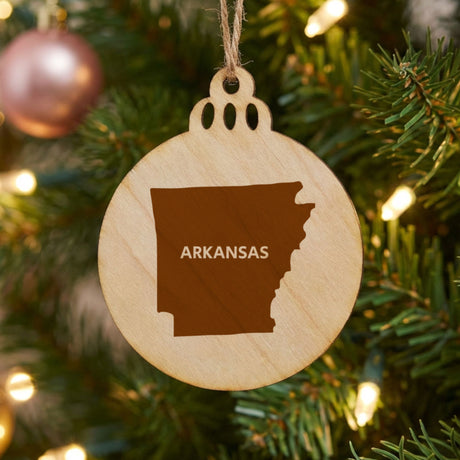 Arkansas round wood Christmas ornament engraved with the state shape and ARKANSAS in bold lettering
