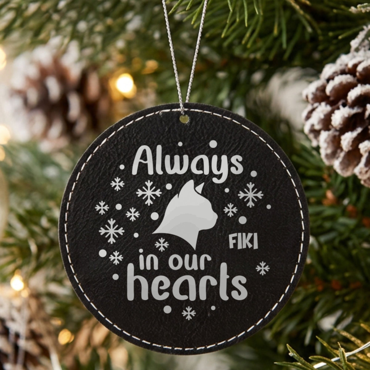 Black leatherette Christmas ornament engraved with the Always in Our Hearts cat design and a sample pet name
