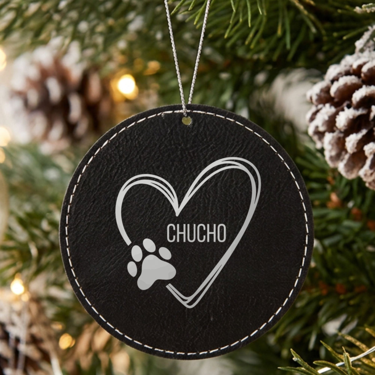Black leatherette Christmas ornament engraved with the heart and paw print design and a sample pet name