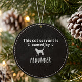 Black leatherette Christmas ornament engraved with the This Cat Servant is Owned By design and a sample pet name