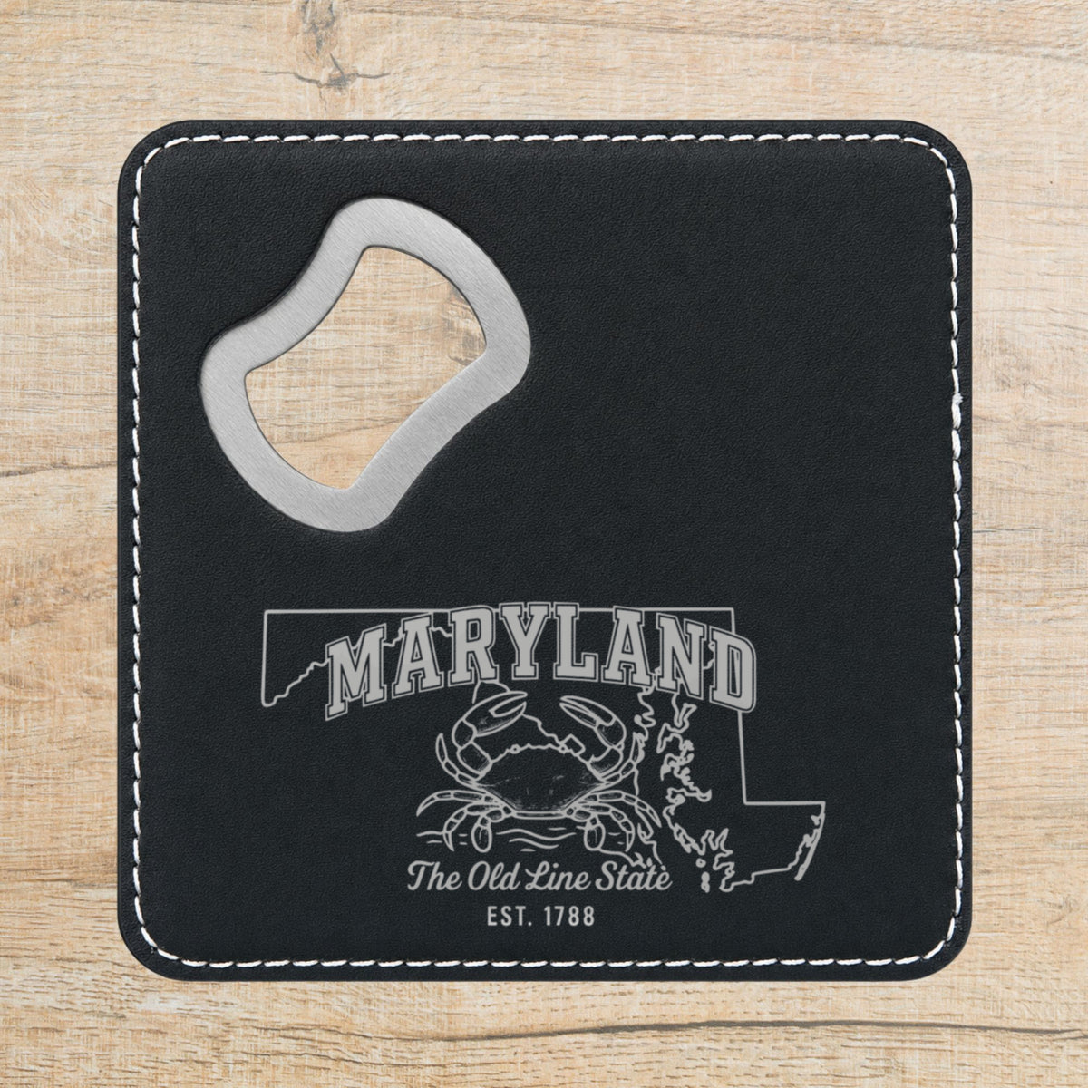 Black leatherette bottle opener coaster laser engraved with a Maryland design of a blue crab on the Chesapeake