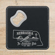Black leatherette bottle opener coaster laser engraved with a Nebraska design of a western meadowlark, a barn and a windmill