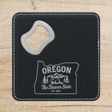 Black leatherette bottle opener coaster laser engraved with an Oregon design of a beaver, mountains and pines