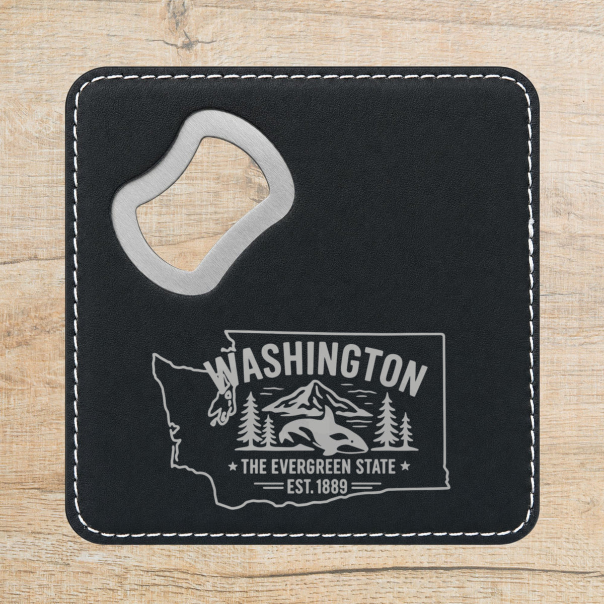 Black leatherette bottle opener coaster laser engraved with a Washington design of an orca, Mount Rainier and evergreens