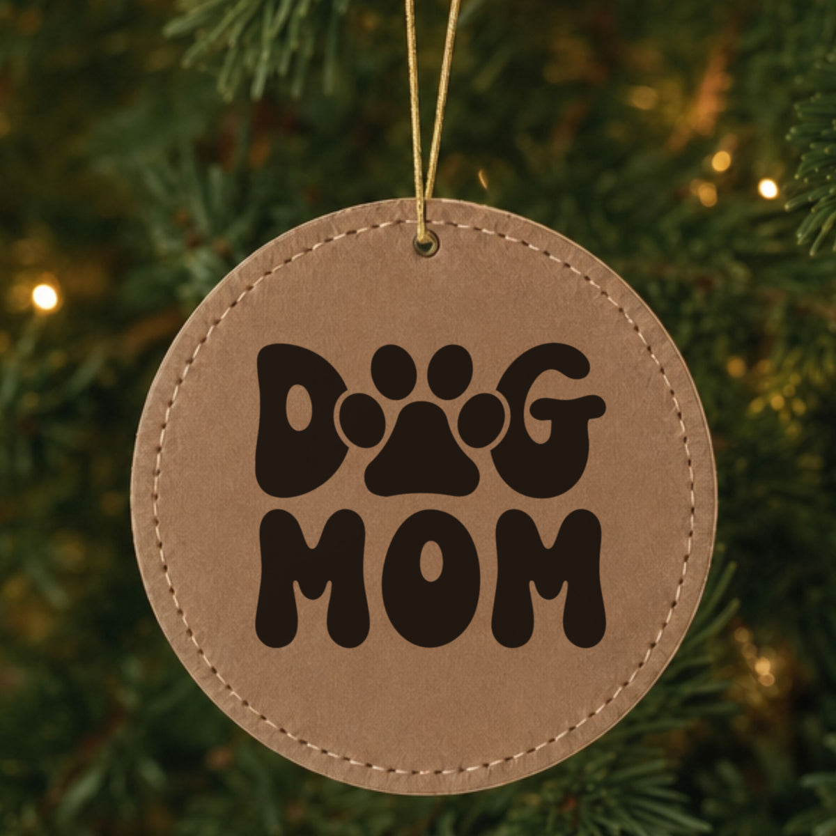 Brown leatherette Christmas ornament engraved with a retro bubble letter Dog Mom design with a paw print