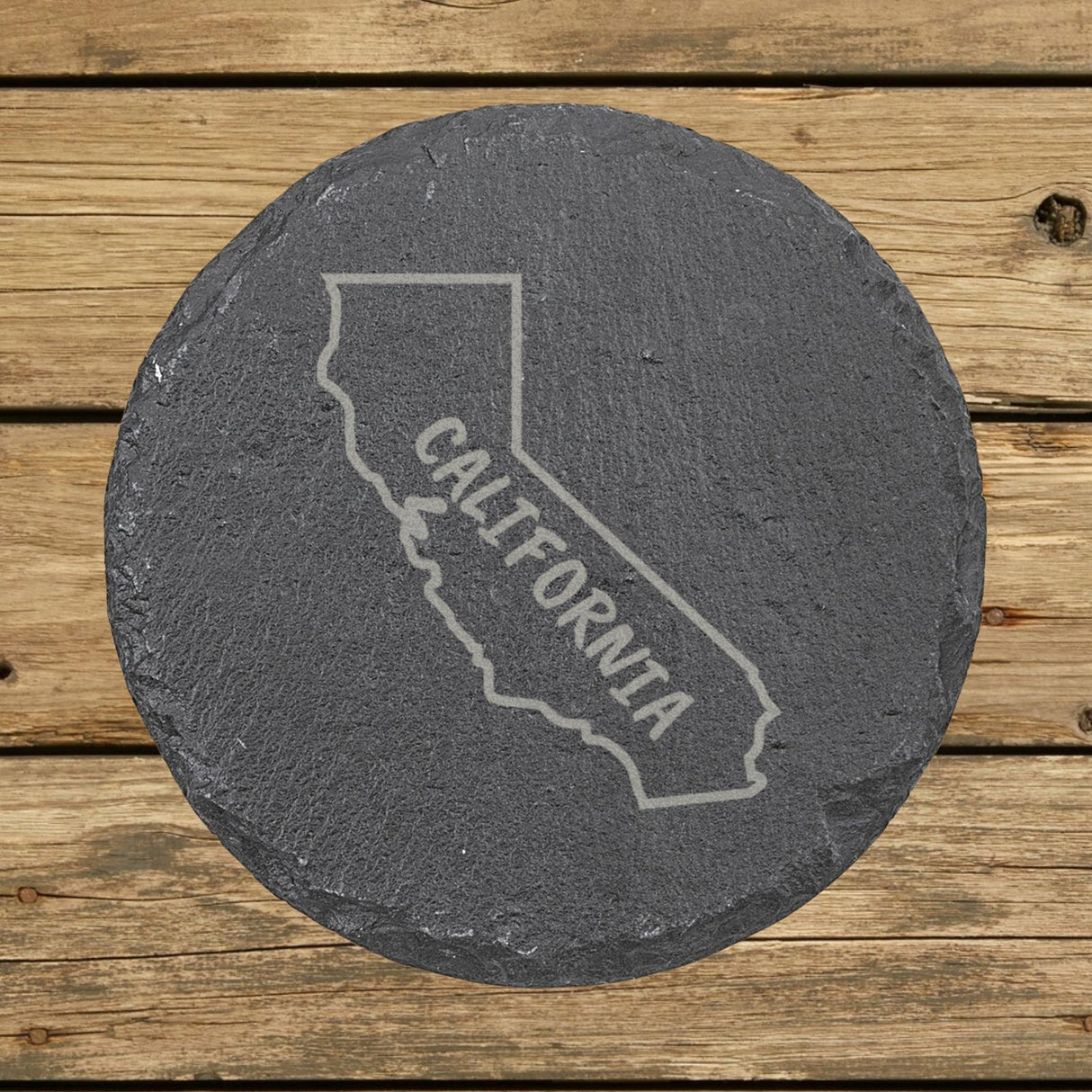 California round slate coaster engraved with the state outline and CALIFORNIA in hand-drawn brush lettering