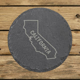 California round slate coaster engraved with the state outline and CALIFORNIA in hand-drawn brush lettering