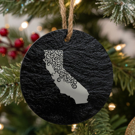 California round slate Christmas ornament engraved with the state shape in ornate floral scrollwork