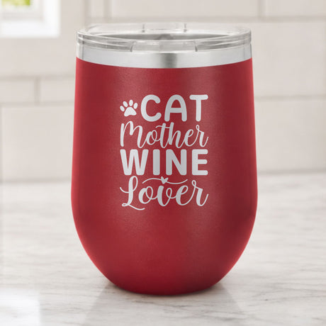 Maroon 12 oz stemless wine tumbler laser engraved with "Cat Mother Wine Lover" and a paw print, on a kitchen counter
