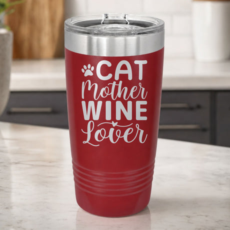 Maroon 20 oz tumbler laser engraved with "Cat Mother Wine Lover" and a paw print, on a kitchen counter