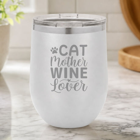 White 12 oz stemless wine tumbler laser engraved with "Cat Mother Wine Lover" and a paw print, on a kitchen counter