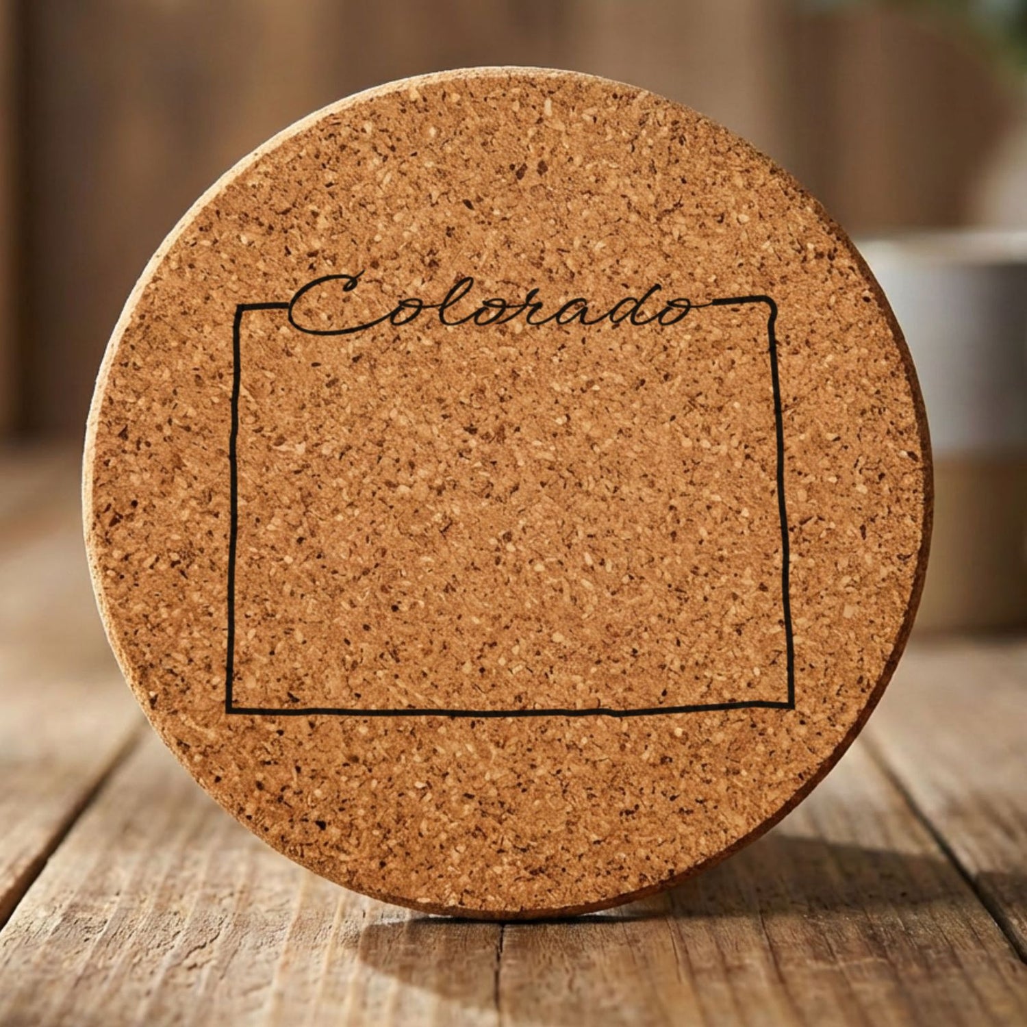 Colorado round cork coaster engraved with the state outline and Colorado in script lettering