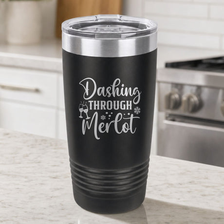 Black 20 oz tumbler laser engraved with "Dashing Through Merlot", on a kitchen counter