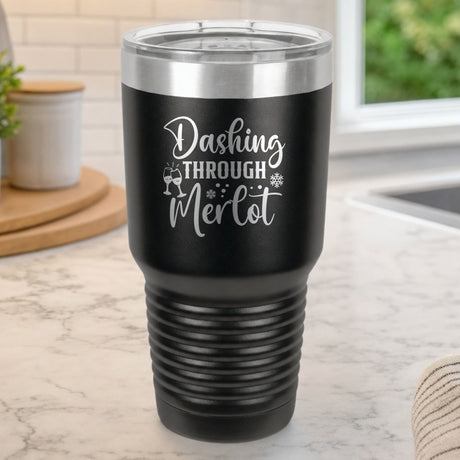 Black 30 oz tumbler laser engraved with "Dashing Through Merlot", on a kitchen counter