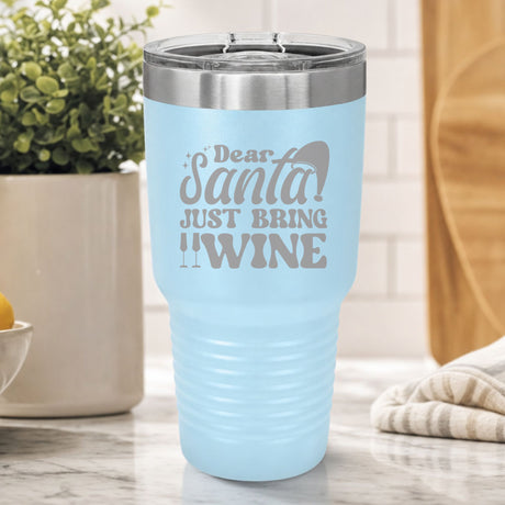 Light Blue 30 oz tumbler laser engraved with "Dear Santa, Just Bring Wine", on a kitchen counter